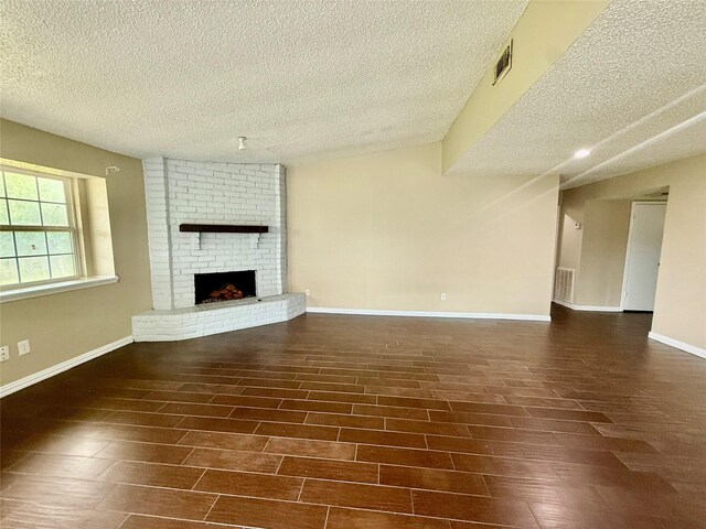 8818 Fern Valley Dr, Houston, TX 77044 - unfurnished living room featuring a textured ceiling, a fireplace, wood finished floors, and baseboards