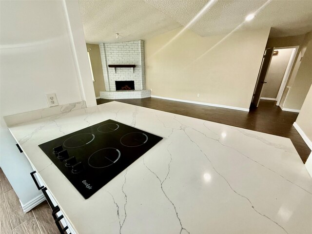 8818 Fern Valley Dr, Houston, TX 77044 - unfurnished living room with a textured ceiling, a brick fireplace, and baseboards