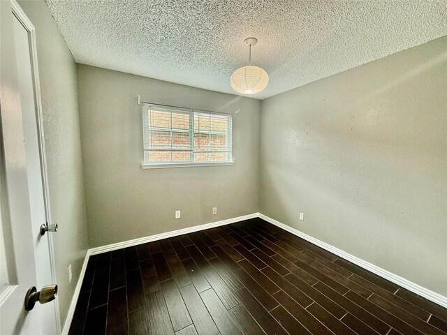 8818 Fern Valley Dr, Houston, TX 77044 - empty room featuring baseboards, a textured ceiling, and dark wood-style floors