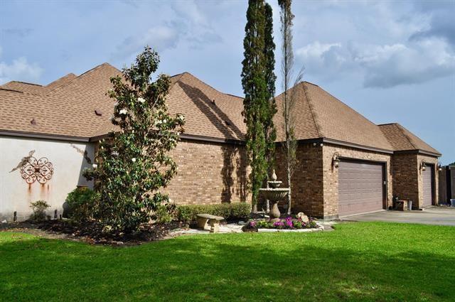 view of front of property with an attached garage, brick siding, driveway, and a front yard