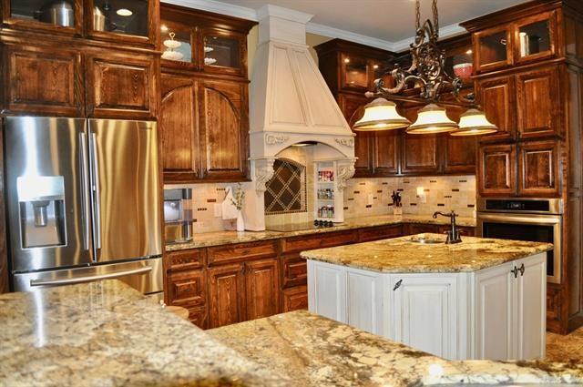 kitchen featuring stainless steel appliances, a sink, light stone countertops, decorative backsplash, and custom exhaust hood