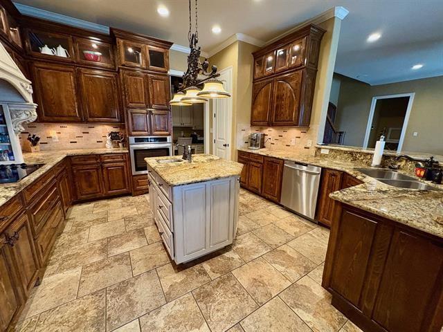 kitchen featuring stainless steel appliances, a sink, backsplash, and crown molding