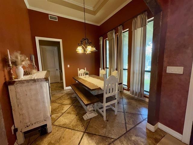 dining space with visible vents, a wealth of natural light, a raised ceiling, and ornamental molding
