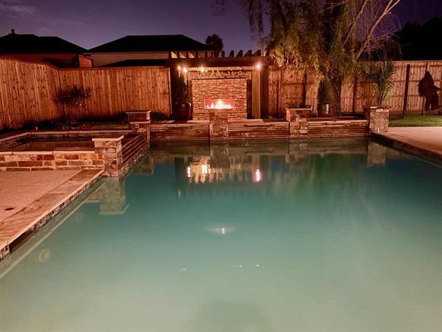 pool at twilight featuring a fenced backyard and a fenced in pool