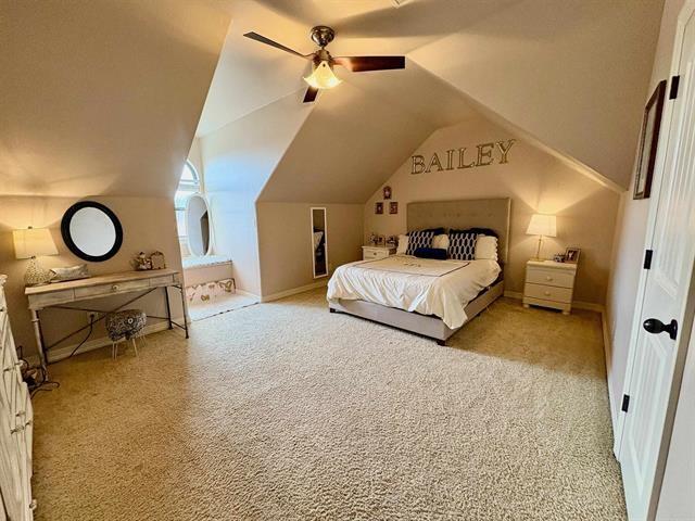 bedroom with a ceiling fan, carpet floors, lofted ceiling, and baseboards