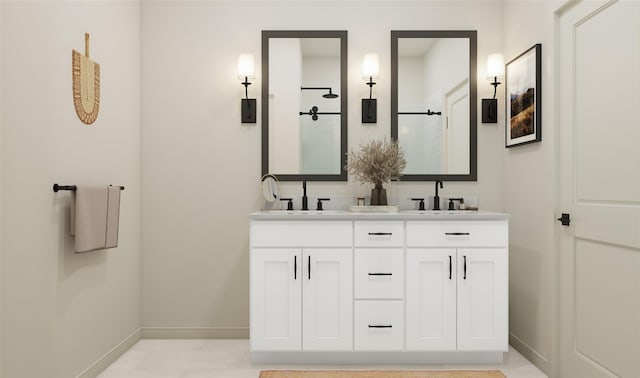 bathroom with a sink, baseboards, walk in shower, and double vanity