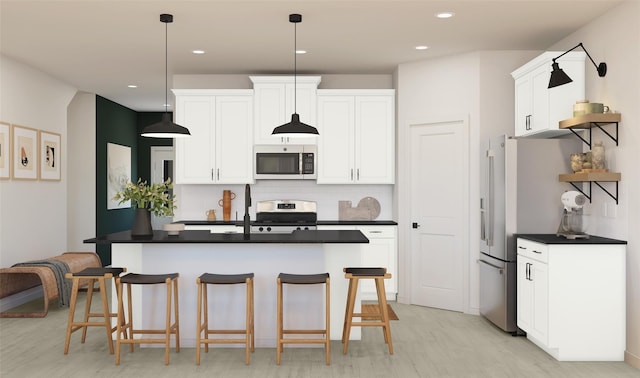 kitchen with dark countertops, appliances with stainless steel finishes, a kitchen breakfast bar, and light wood finished floors