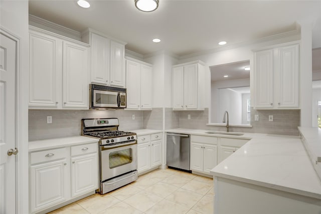 kitchen with light countertops, white cabinetry, stainless steel appliances, and a sink