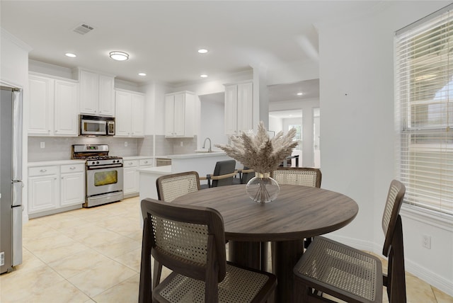 dining space with light tile patterned floors, baseboards, ornamental molding, visible vents, and recessed lighting