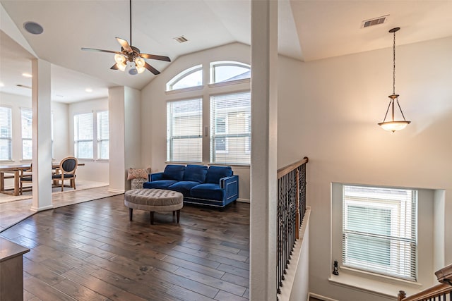 living room with vaulted ceiling, visible vents, dark wood-style floors, and ceiling fan