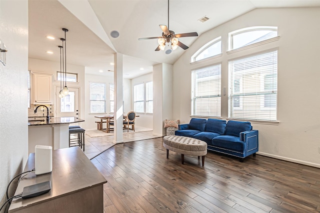 living room featuring vaulted ceiling, visible vents, a ceiling fan, and dark wood-style flooring