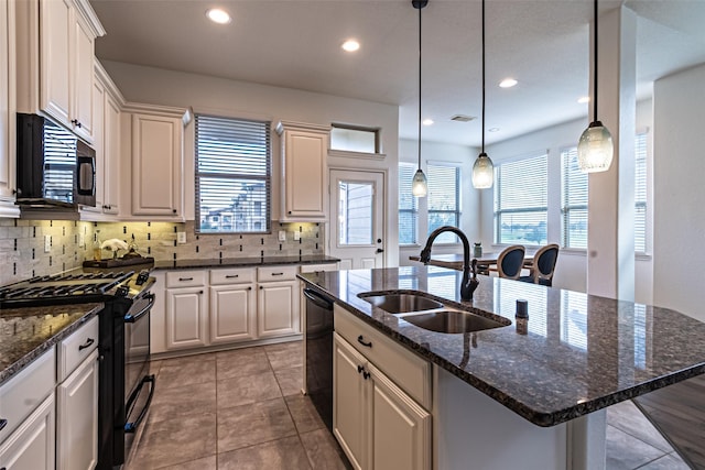 kitchen with black appliances, a wealth of natural light, decorative backsplash, and a sink