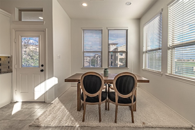 tiled dining room with recessed lighting
