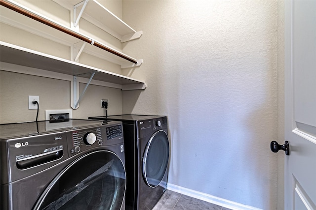 laundry area featuring separate washer and dryer, baseboards, a textured wall, and laundry area