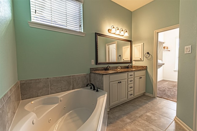 bathroom featuring double vanity, a jetted tub, tile patterned flooring, and a sink