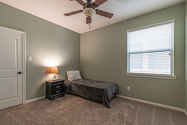 carpeted bedroom with a ceiling fan and baseboards