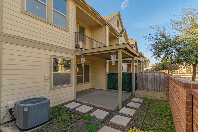 view of home's exterior with central AC unit, a patio, a balcony, and fence