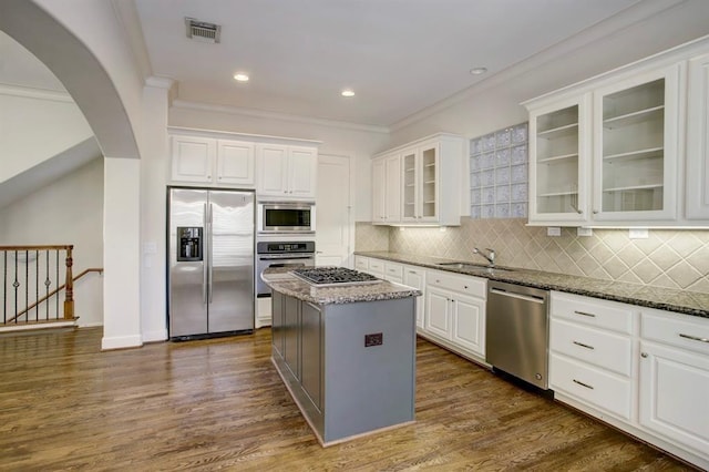 kitchen with a sink, dark stone counters, visible vents, white cabinetry, and appliances with stainless steel finishes