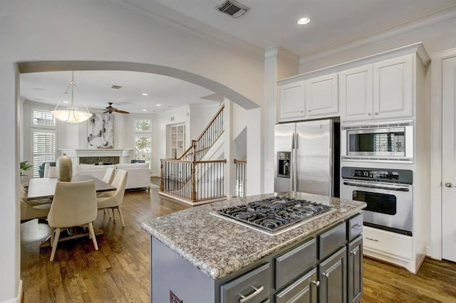 kitchen with stainless steel appliances, visible vents, gray cabinets, arched walkways, and ceiling fan