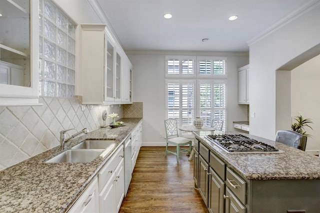 kitchen featuring crown molding, white dishwasher, a sink, stainless steel gas stovetop, and dark wood-style floors