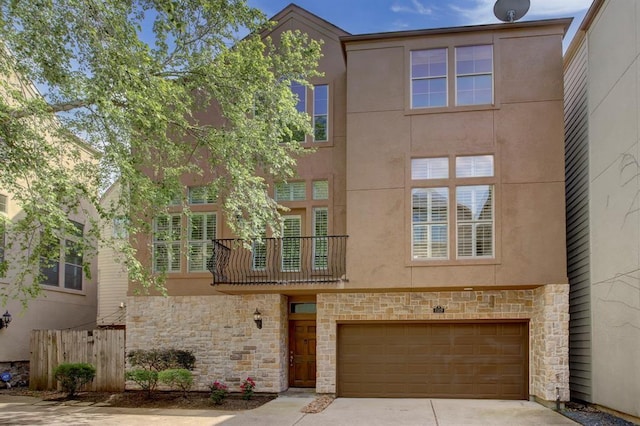 multi unit property with stone siding, an attached garage, concrete driveway, and stucco siding