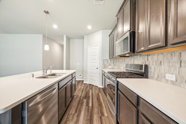 kitchen with dark wood-type flooring, light countertops, appliances with stainless steel finishes, and a sink
