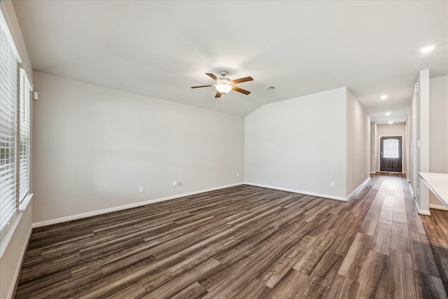unfurnished living room featuring dark wood-style flooring, baseboards, and ceiling fan