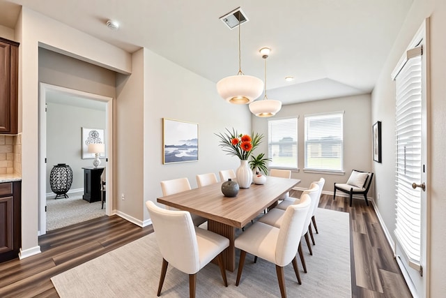 dining space featuring visible vents, baseboards, dark wood-style floors, and lofted ceiling