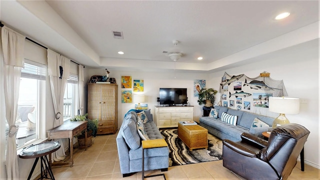 living area with recessed lighting, a tray ceiling, visible vents, and light tile patterned floors