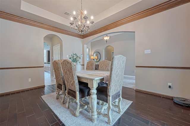 dining space featuring arched walkways, visible vents, an inviting chandelier, and a tray ceiling