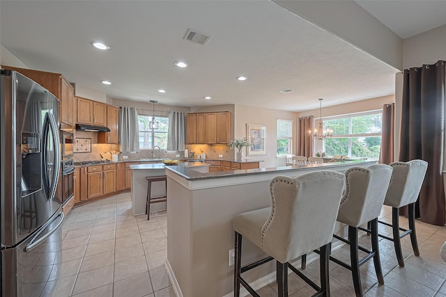 kitchen featuring recessed lighting, appliances with stainless steel finishes, a center island, visible vents, and a notable chandelier