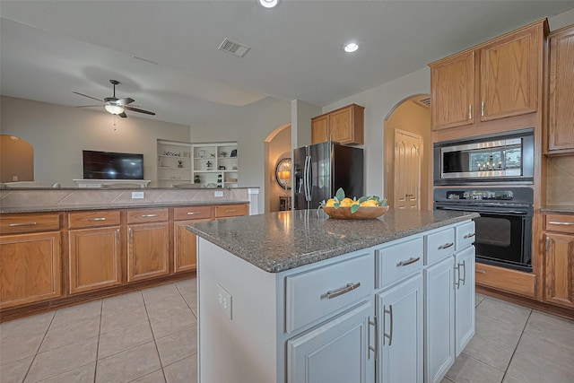 kitchen featuring light tile patterned floors, arched walkways, visible vents, and appliances with stainless steel finishes
