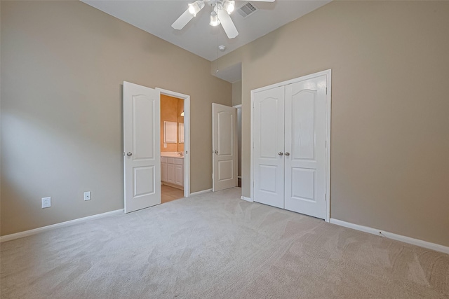 unfurnished bedroom featuring visible vents, ensuite bathroom, a closet, baseboards, and light carpet