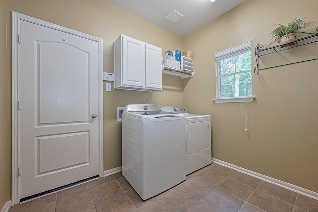 washroom featuring light tile patterned floors, cabinet space, washing machine and clothes dryer, and baseboards