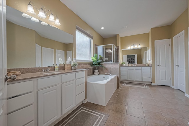 full bath featuring tile patterned flooring, two vanities, a shower stall, a bath, and a sink