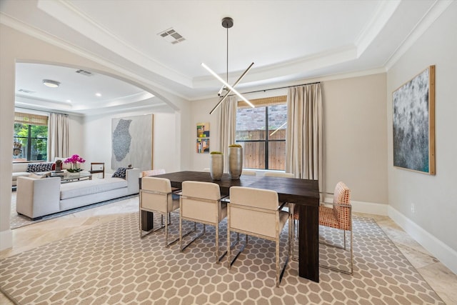 dining area featuring a raised ceiling, ornamental molding, arched walkways, and visible vents