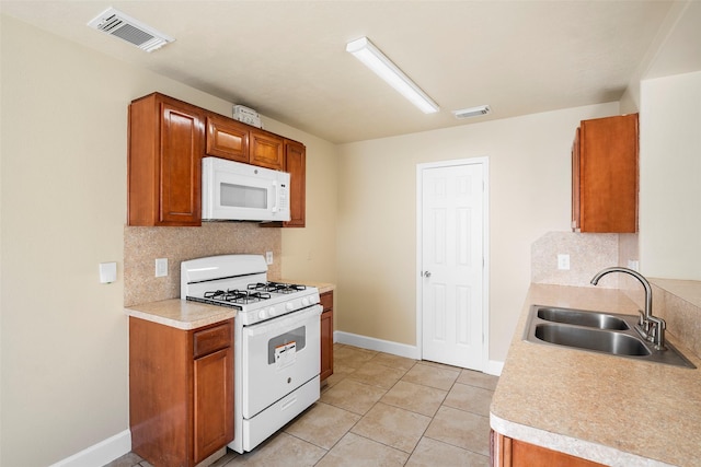 kitchen with tasteful backsplash, visible vents, a sink, and white appliances