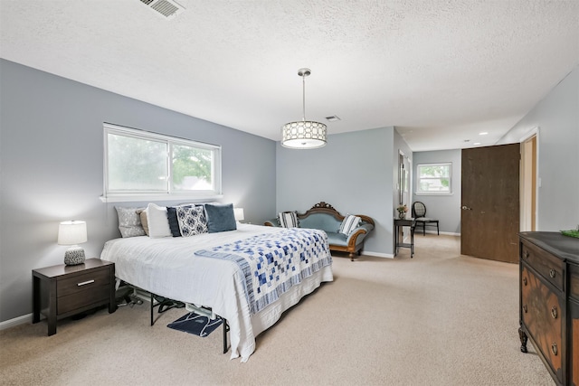 bedroom with light carpet, baseboards, visible vents, and a textured ceiling