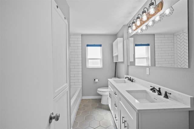 bathroom featuring double vanity, tile patterned flooring, toilet, and a sink
