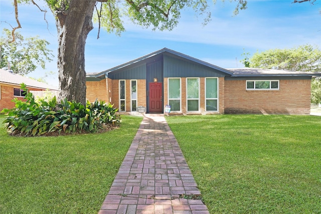 mid-century home with brick siding and a front yard