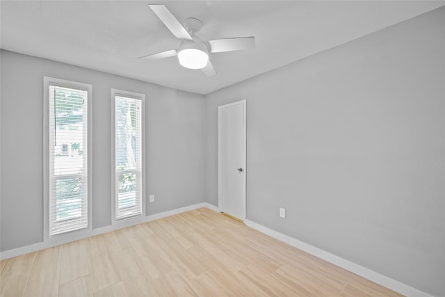 empty room featuring wood finished floors, a ceiling fan, and baseboards
