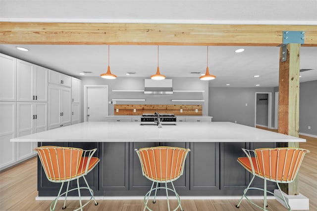 kitchen featuring white cabinets, a large island with sink, light countertops, and recessed lighting