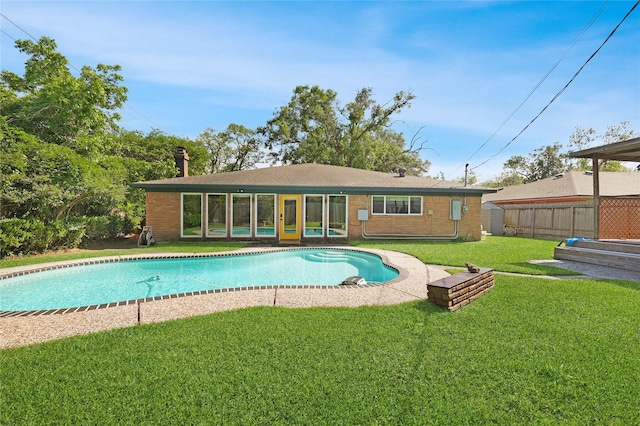 view of swimming pool with a sunroom, fence, a yard, and a fenced in pool