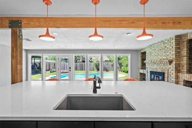 kitchen featuring a wealth of natural light, open floor plan, a sink, and a fireplace