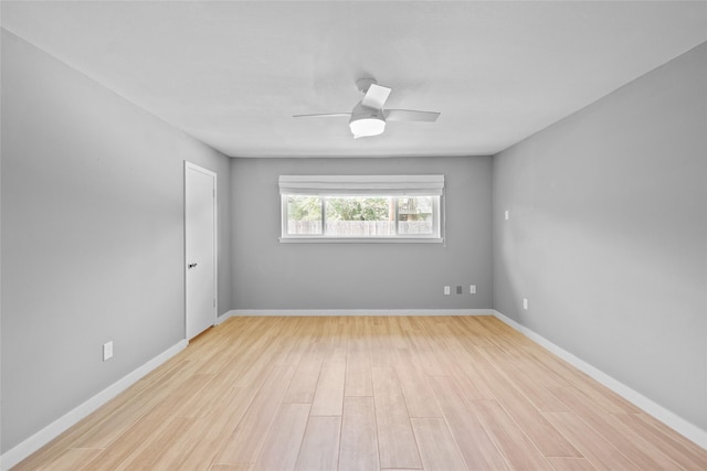 spare room featuring light wood-style flooring, baseboards, and a ceiling fan