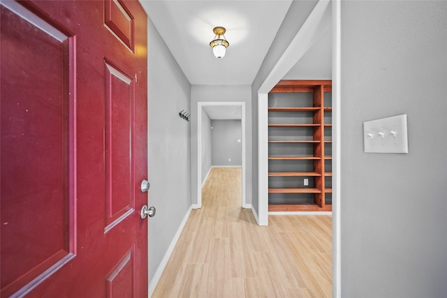foyer entrance with light wood-style flooring and baseboards