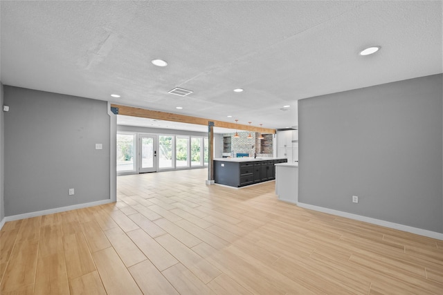 unfurnished living room with recessed lighting, light wood-style floors, visible vents, and baseboards