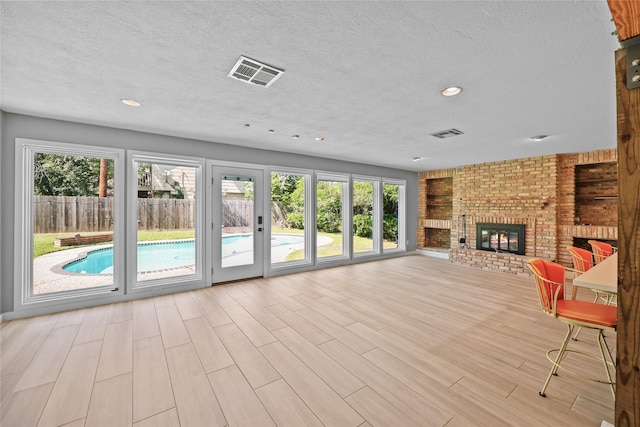 living room featuring wood finished floors, visible vents, and a textured ceiling
