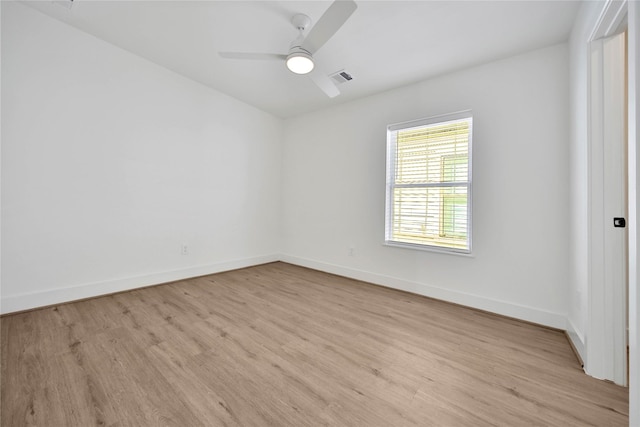 spare room featuring light wood-style flooring, visible vents, baseboards, and ceiling fan