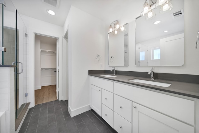 bathroom with a shower stall, tile patterned flooring, a sink, and visible vents